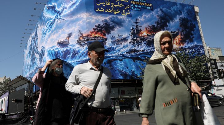 People walk past a billboard about the Strait of Hormuz, on a building in Tehran, Iran, September 16, 2026.